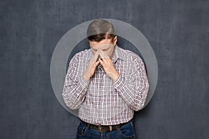 Portrait of upset unhappy man covering face with hands