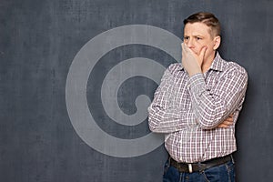 Portrait of upset unhappy man covering mouth with hand