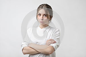 Portrait of an upset unsatisfied european woman standing with arms crossed and looking at camera