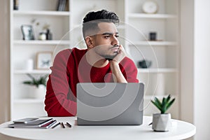 Portrait Of Upset Young Arab Male Bored Working On Laptop