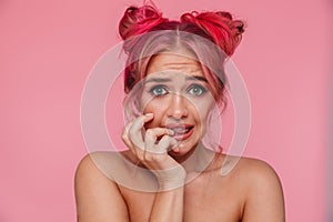 Portrait of uptight shirtless young woman frowning and biting nails