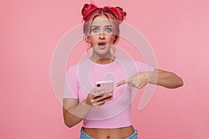 Portrait of uptight woman with colored hair pointing finger at cellphone