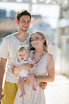 A Portrait from vacation. Happy family with kid walking together outside.