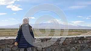 Portrait of vacation travel little girl looking at Ararat mountain landscape. Nature during summer vacations. Young kid