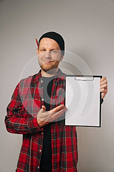 Portrait vertical of a cheerful caucasian male builder holding a tool bag and white paper for text