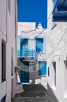 Portrait vertical view of Plaka Town street on Milos Island, Greece with no people. Traditional architecure with whitewashed house