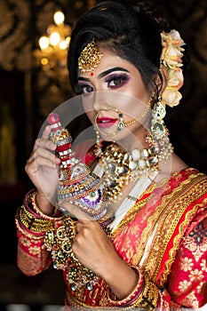 Portrait of very beautiful Indian bride holding traditional wooden sindur or sindoor box in hand, Wedding symbol sindoor box photo
