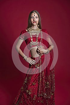 Portrait of very beautiful young Indian bride in luxurious bridal costume with makeup and heavy jewellery