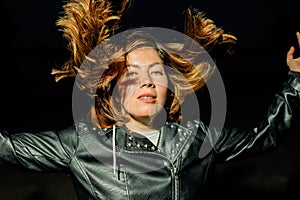 Girl on a black background with dark hair sweeping around her head