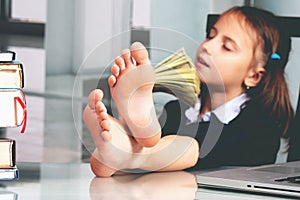 Portrait of very happy cute young business girl counts money profit. Selective focus on bare feet