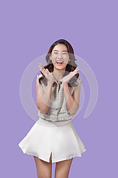 Portrait of very happy, jovial laughing beautiful young asian woman isolated against purple background