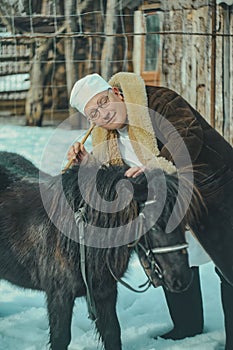 Portrait of a veterinarian. Doctor with medical equipment and suitcase outdoors in winter.