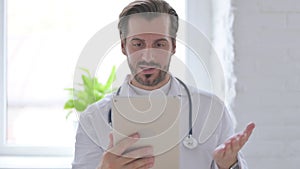 Portrait of Video Call on Tablet by Young Doctor in Office