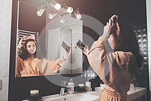 Portrait view of beautiful young woman making selfie in home bathroom. mirror face reflection. Social networks