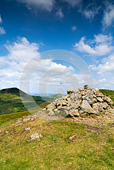 A portrait view of Caer Caradoc and The Lawley Hills in the Shropshire Hills with a collection of Cairns in the foreground photo