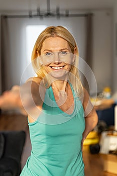 Portrait view of the grandmother in sportswear warming up and doing morning exercises. Cheerful and active senior woman