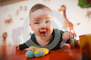 Portrait view of happy cute smiling baby boy with toys