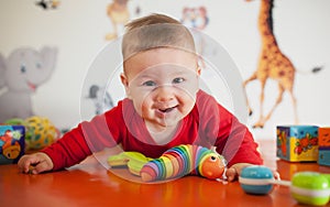 Portrait view of happy cute smiling baby boy with toys