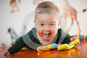 Portrait view of happy cute smiling baby boy with toys