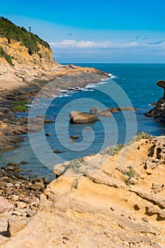 Portrait View of the Ocean with scattered Clouds and Mountain cliff.