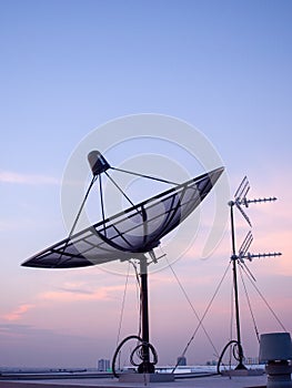 Portrait view of satellite dish on top of the building.