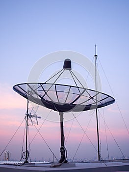 Portrait view of satellite dish on top of the building.