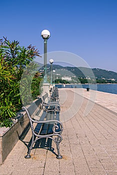 Portrait view of wooden benches in straight row on the Opatija w