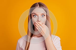 Portrait of voiceless crazy stupor lady hand cover mouth silent reaction on yellow background photo