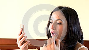 Portrait of a voluptuous woman putting lipstick