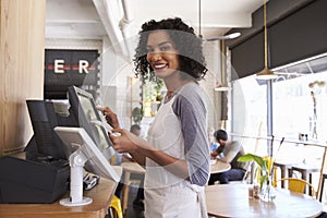 Portrait Of Waitress At Cash Register In Coffee Shop photo