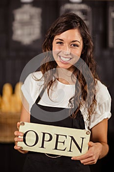 Portrait of a waitress showing open sign