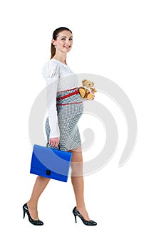 Portrait of walking pregnant businesswoman with document case an