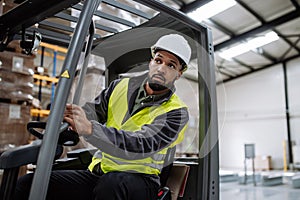 Portrait of warehouse worker driving forklift. Warehouse worker preparing products for shipmennt, delivery, checking