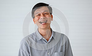 Portrait of warm personality senior older Asian man in casual dress friendly pose and laughing with happy and successful feeling