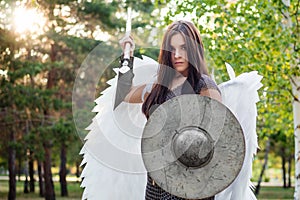 Portrait of a warrior woman in chain mail with steel bracers and wings behind her back.