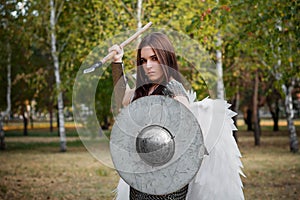 Portrait of a warrior woman in chain mail with steel bracers and wings behind her back.