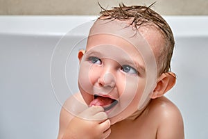 Portrait of a washing toddler baby boy in the bath, happy child. Smiling