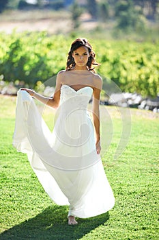 Portrait, wedding dress and woman in nature, grass and outdoor for marriage. Bride holding gown, young person barefoot