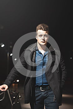 Portrait of well-dressed handsome young stylish man climbing up the stairs