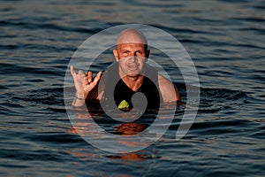 Portrait of wet man in water showing surfer gesture