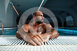 Portrait Of A Wet Sexy Muscular Man Standing In Swimming Pool