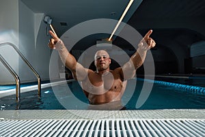 Portrait Of A Wet Sexy Muscular Man Standing In Swimming Pool