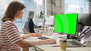 Portrait of White Creative Young Woman Working on a Green Screen Computer in Busy Office. Female