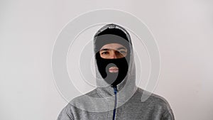 Portrait of a white man in a black balaclava. Thief or criminal is looking at the camera.