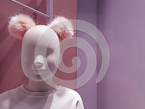Portrait of a white mannequin girl on a background of bright colorful warm pink shades. Little doll in a shop window. Boutique