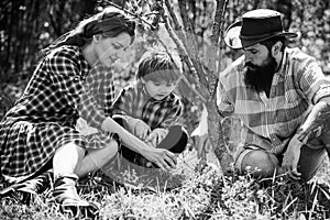 Portrait of wife and husband with son while working in garden. Worker family agriculture. Happy family spending time