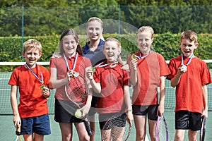 Portrait Of Winning School Tennis Team With Medals