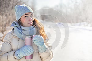 Portrait winter woman with natural hair face beauty holding thermo mug posing frozen sunny forest