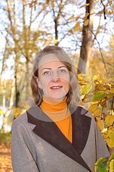 Portrait of a woman against the background of autumn foliage