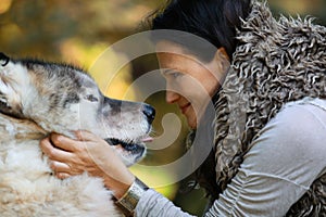 Portrait of a woman with an Alaskan Malamute dog in the forest